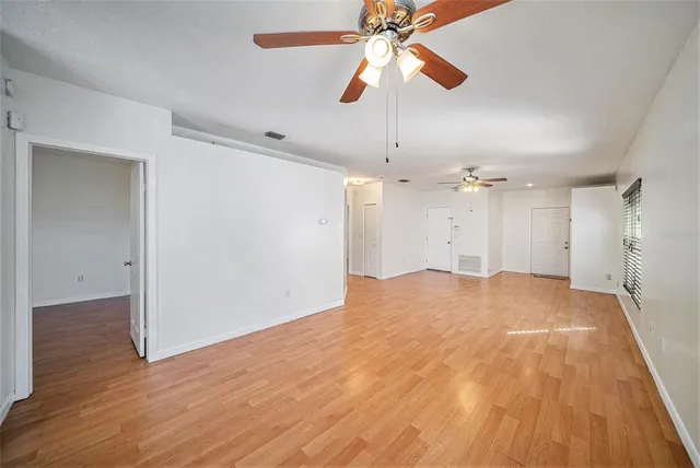 wooden floor in an empty room with a fan