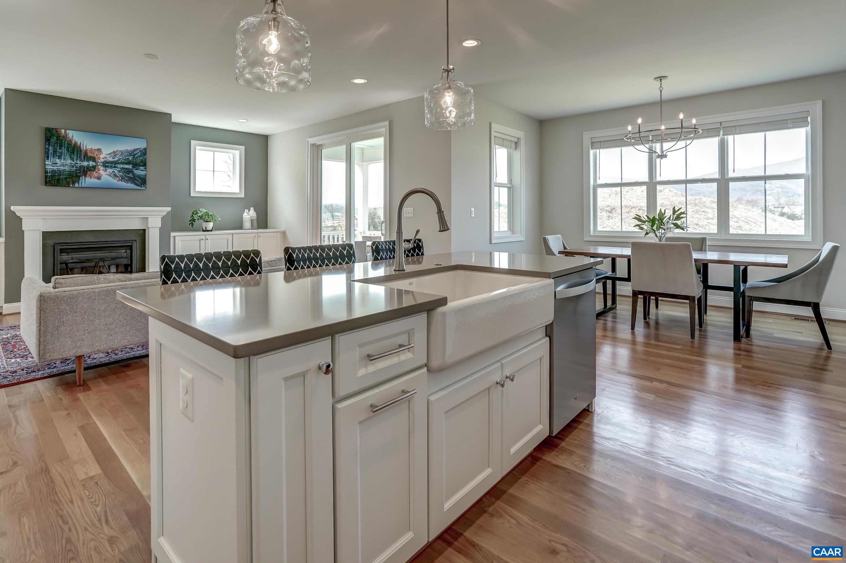 424 Claibourne Road Crozet, VA 22932 - Photo 19 of 64 a kitchen with granite countertop a stove a sink a dining table and chairs with wooden floor