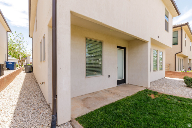 3157 Deseret Drive St. George, UT 84790 - Photo 21 of 24 Outdoor patio area featuring a concrete slab and direct entry, complemented by a strip of manicured lawn and a gravel-covered side yard