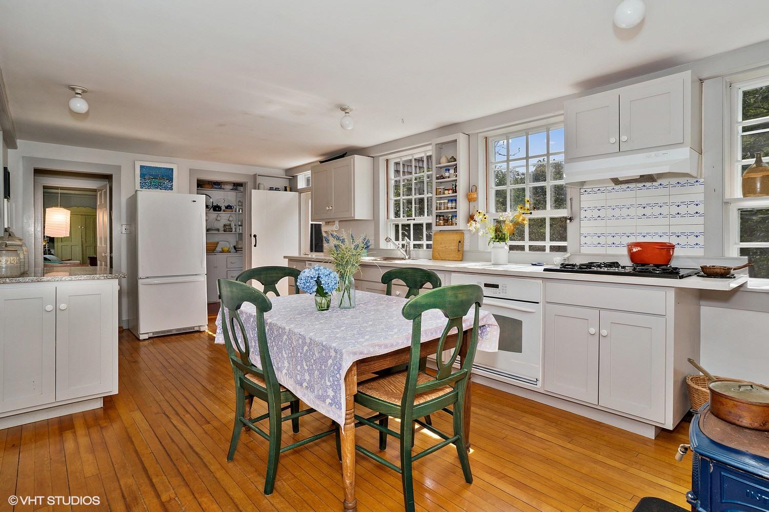35 Mill Hill Road Wellfleet, MA 02667 - Photo 9 of 25 a kitchen with stainless steel appliances a dining table chairs refrigerator and sink