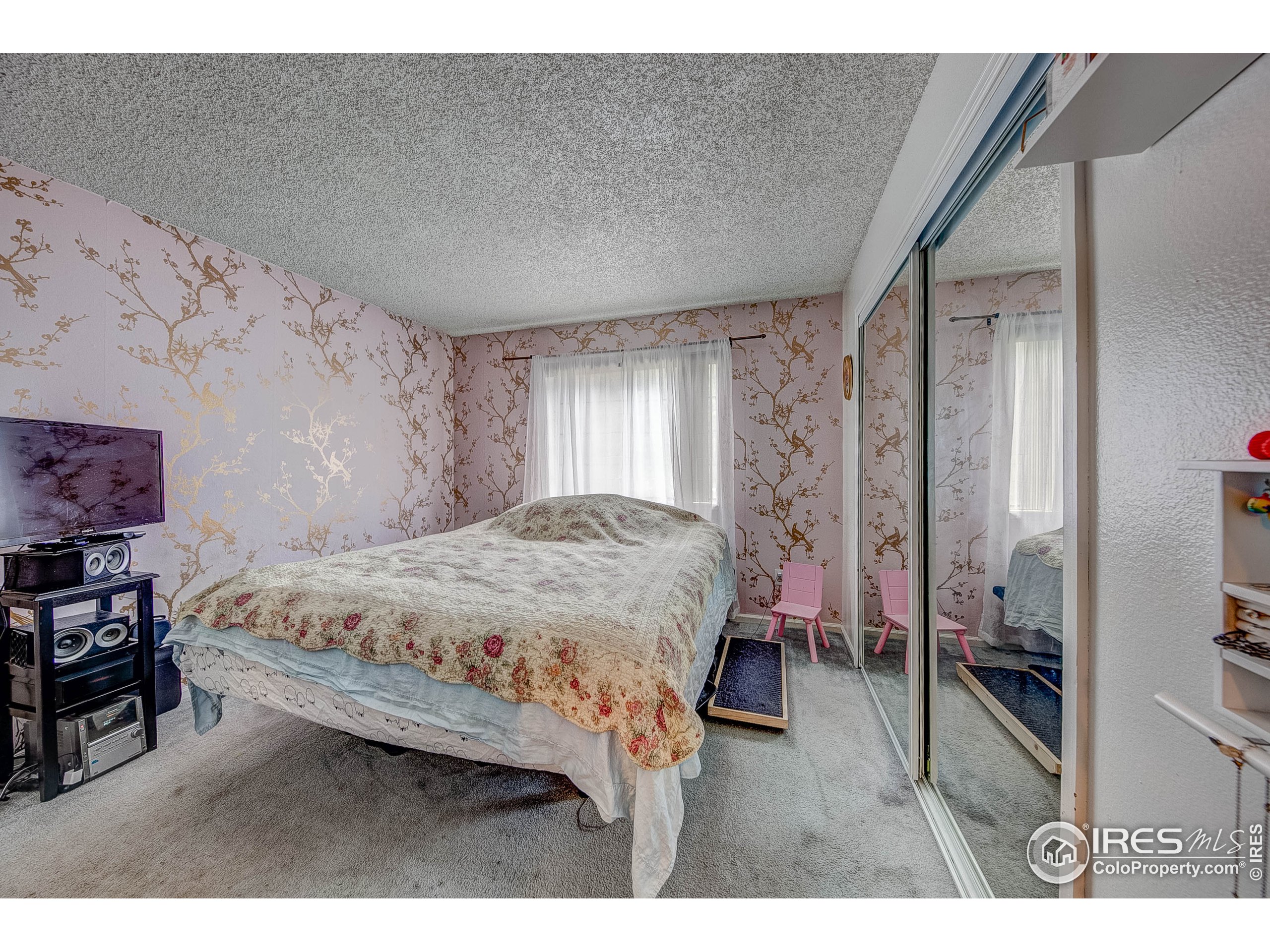 1640 Kirkwood Drive, Unit 2022 Fort Collins, CO 80525 - Photo 16 of 20 a bedroom with a bed closet and a flat tv screen