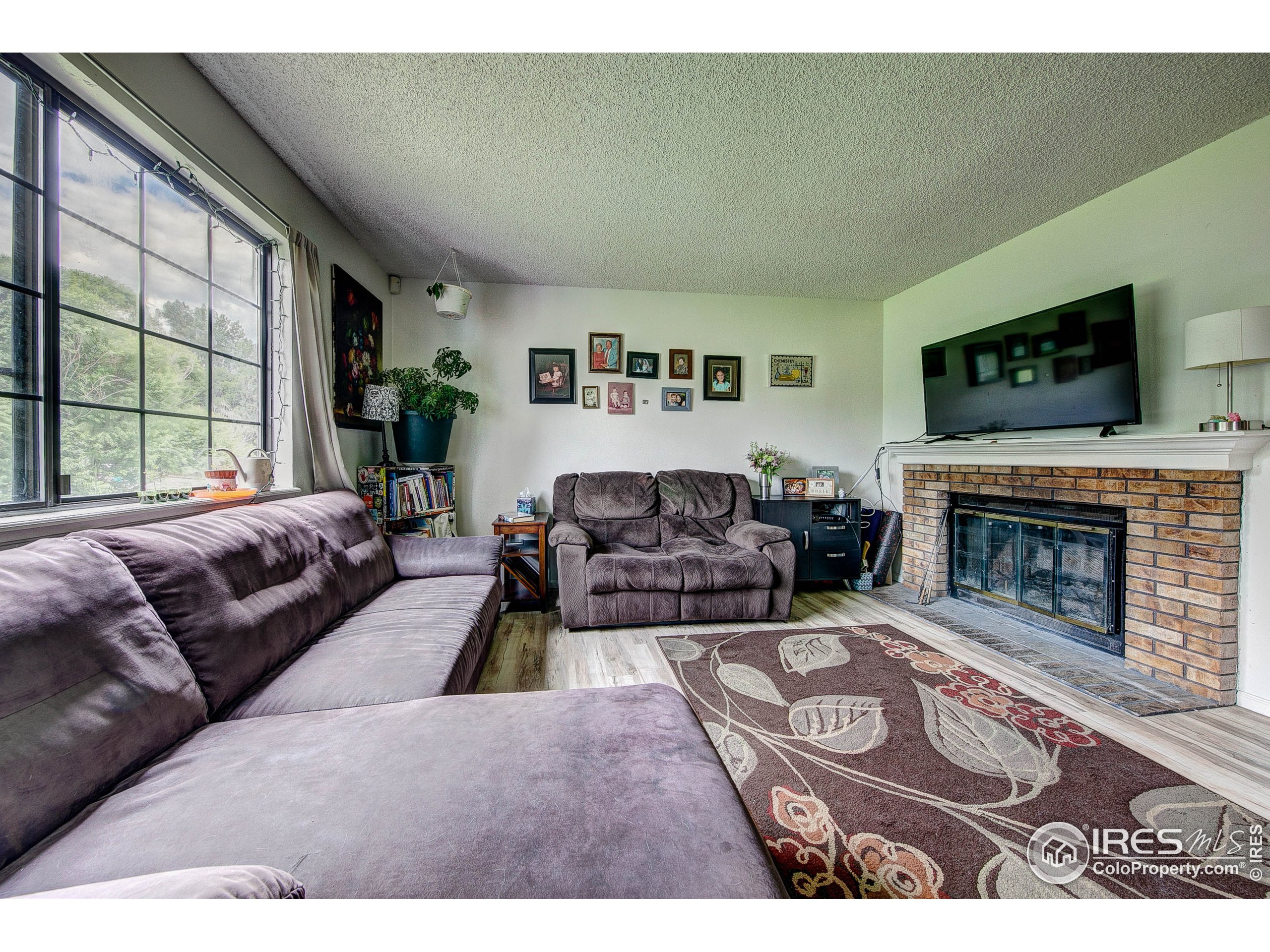 1640 Kirkwood Drive, Unit 2022 Fort Collins, CO 80525 - Photo 6 of 20 a living room with furniture a flat screen tv and a fireplace