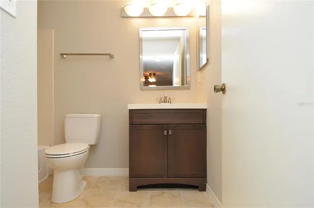a kitchen with granite countertop a stove a sink a counter top space and cabinets