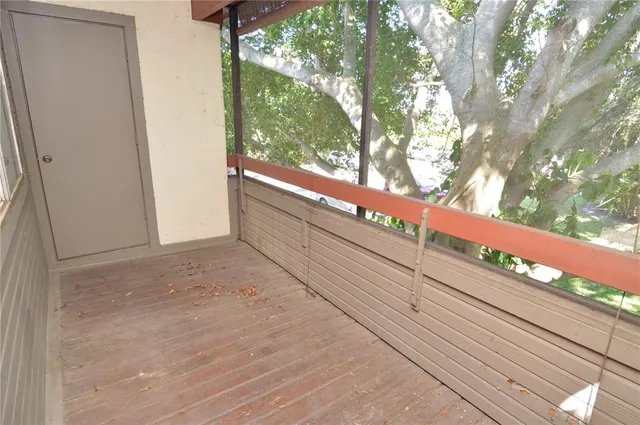 a view of swimming pool with seating space and trees in the background