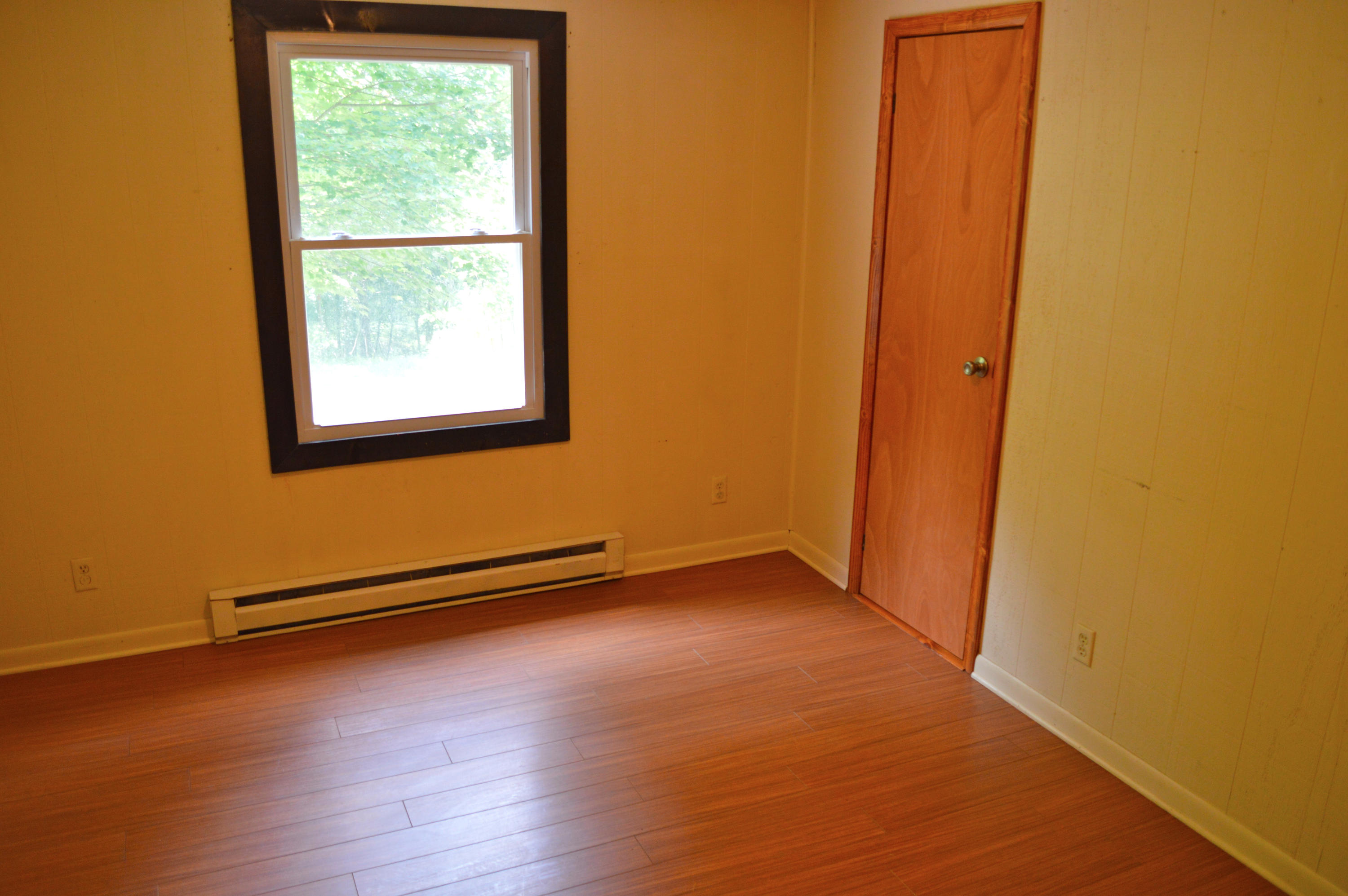 5075 Alum Ridge Road Northwest Riner, VA 24149 - Photo 11 of 28 an empty room with wooden floor and windows