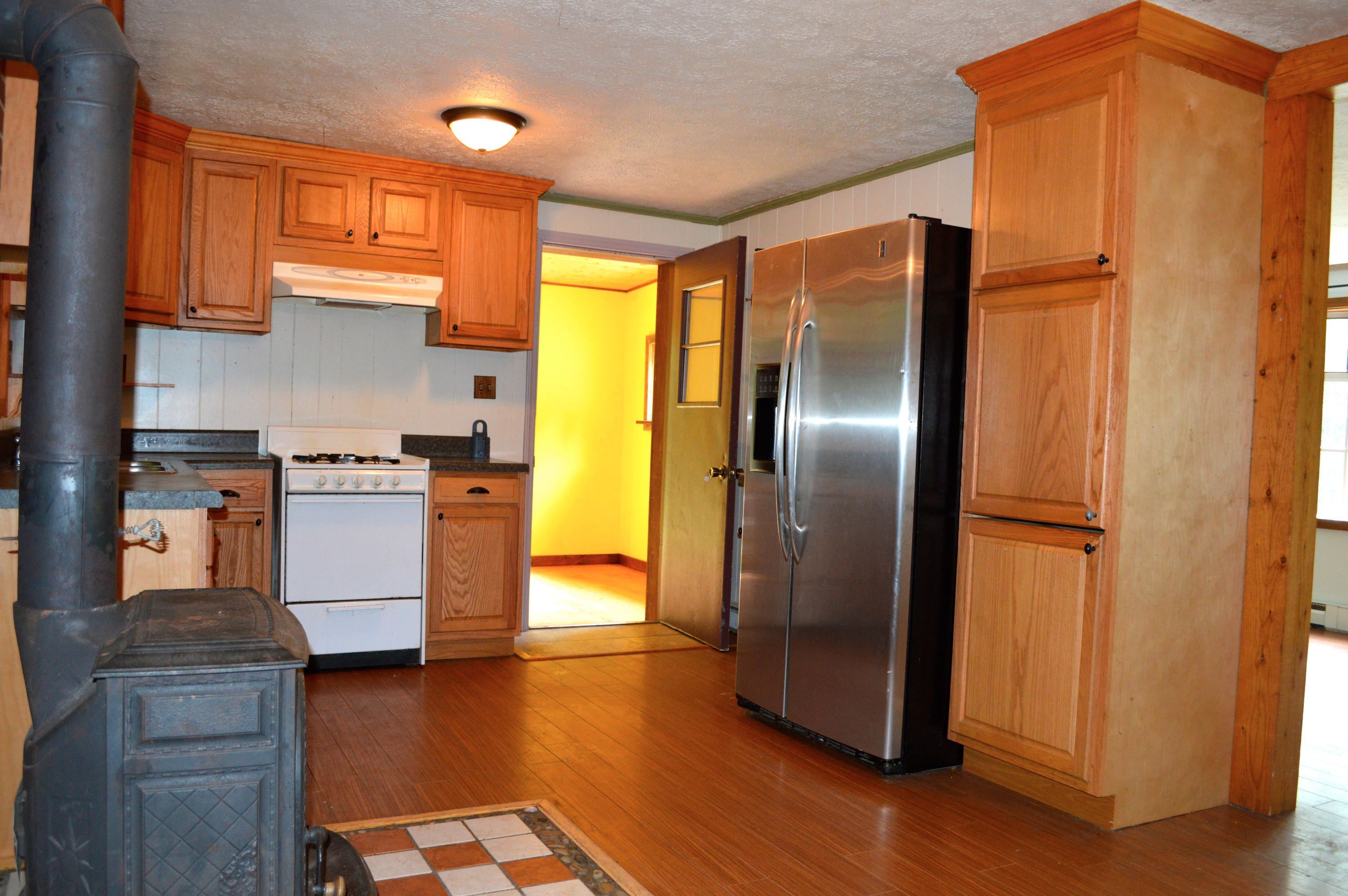5075 Alum Ridge Road Northwest Riner, VA 24149 - Photo 7 of 28 a kitchen with stainless steel appliances granite countertop a refrigerator a sink and a stove with wooden floor