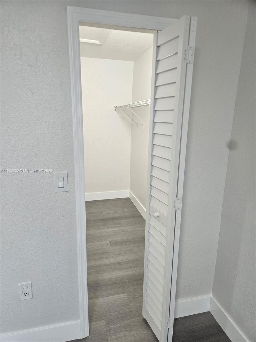 6752 Northwest 182nd Street, Unit 101 Hialeah, FL 33015 - Photo 19 of 23 a view of walk in closet with empty racks