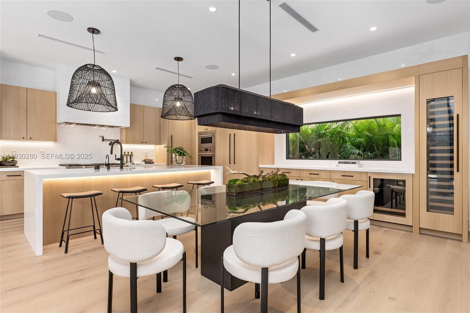 4024 Bonita Avenue Miami, FL 33133 - Photo 13 of 99 a kitchen with stainless steel appliances granite countertop a sink a stove a dining table and chairs with wooden floor