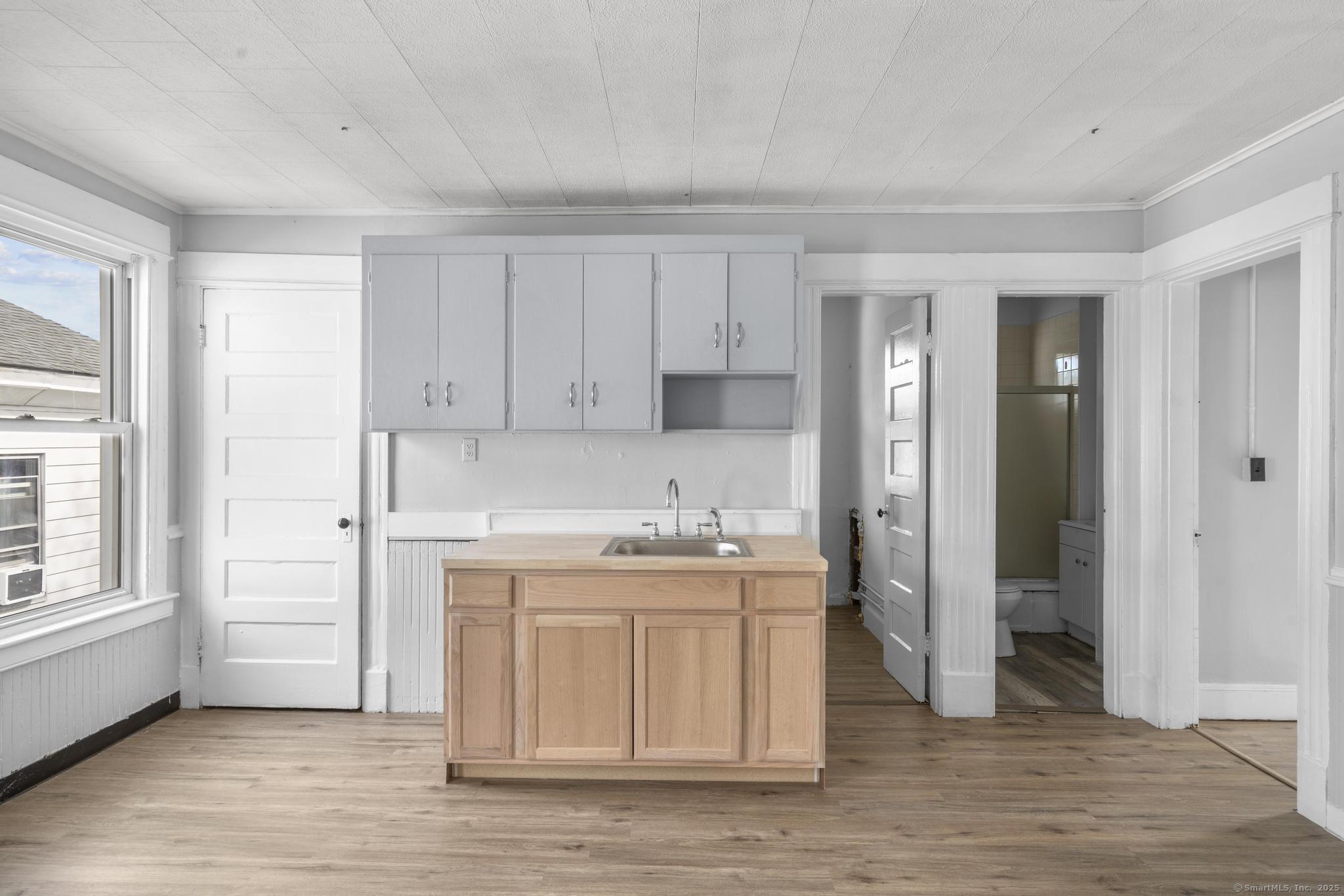 73 South Street Waterbury, CT 06706 - Photo 5 of 29 a view of a kitchen with white cabinets and wooden floor