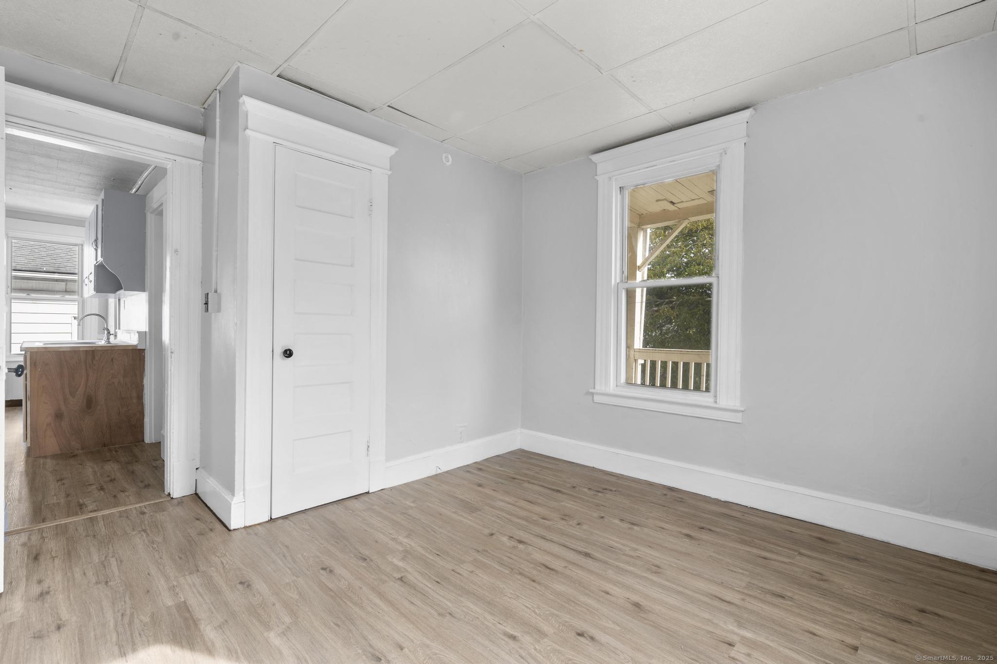 73 South Street Waterbury, CT 06706 - Photo 8 of 29 an empty room with wooden floor and windows