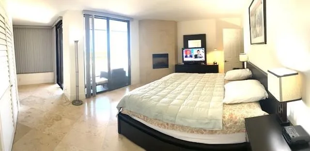 a spacious bedroom with a bed and a cabinets