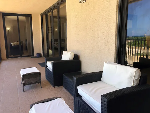 a balcony with furniture and a potted plant