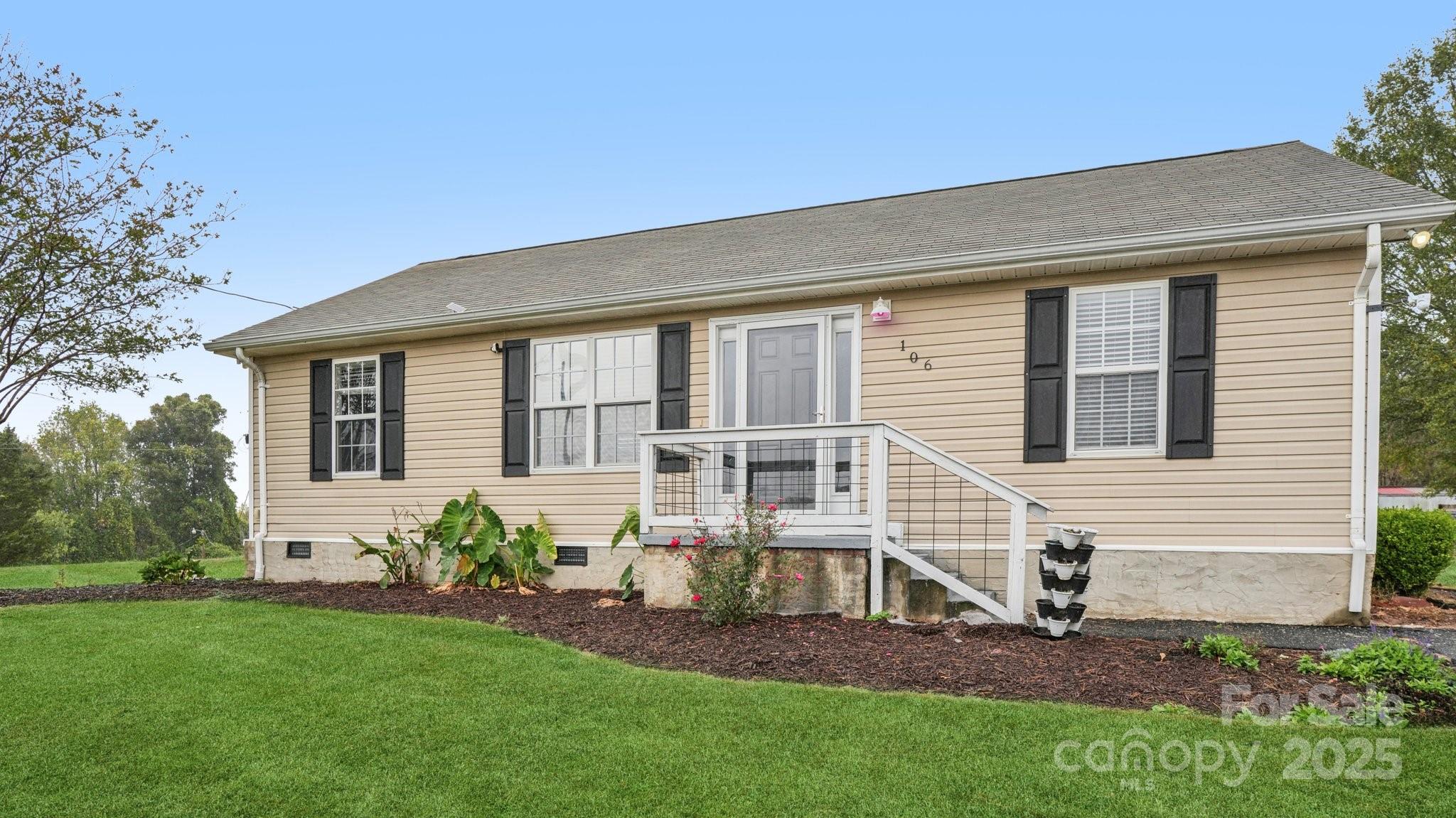 a front view of a house with a garden and plants