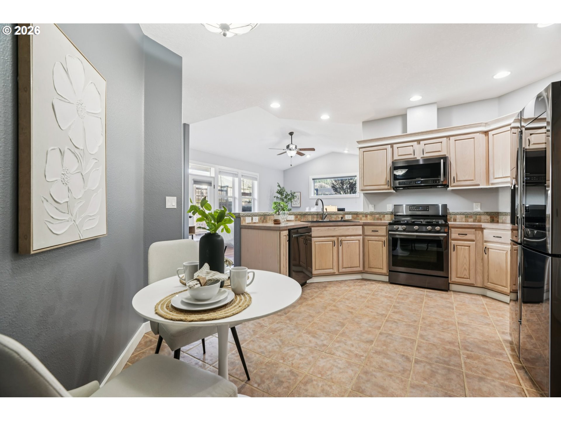 13728 Southwest 159th Terrace Portland, OR 97224 - Photo 12 of 48 a kitchen with stainless steel appliances a stove a sink a microwave a kitchen island and chairs