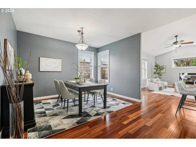 a dining room with wooden floor a chandelier a wooden table and chairs
