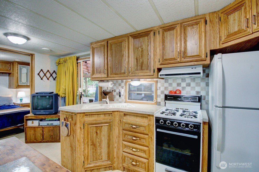22 Wilderness Way Maple Falls, WA 98266 - Photo 22 of 40 a kitchen with stainless steel appliances granite countertop a stove a sink dishwasher and a refrigerator with wooden cabinets