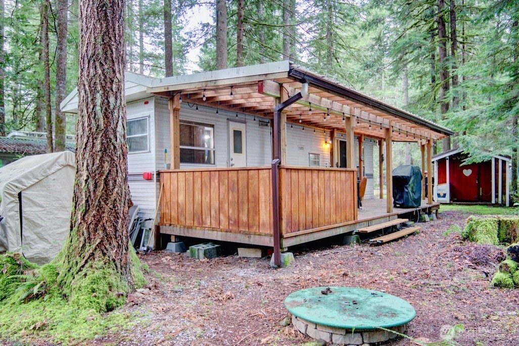 22 Wilderness Way Maple Falls, WA 98266 - Photo 4 of 40 a backyard of a house with barbeque oven fire pit table and chairs