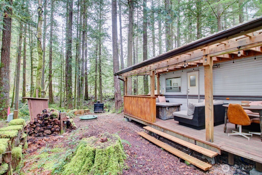 22 Wilderness Way Maple Falls, WA 98266 - Photo 7 of 40 a backyard of a house with barbeque oven table and chairs