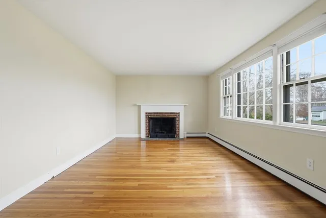 a view of an empty room with a window and fireplace