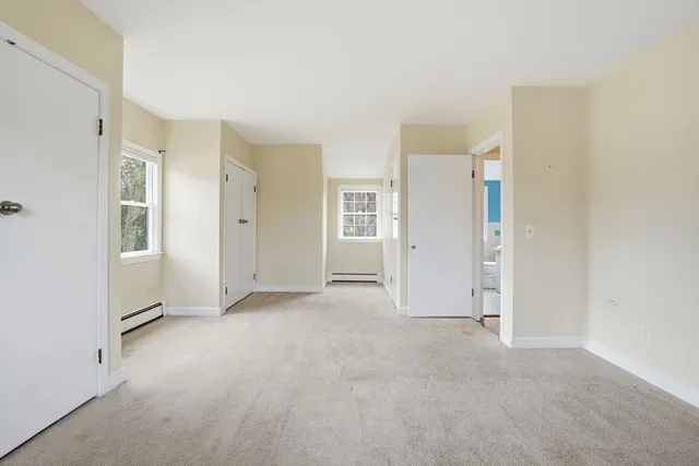 an empty room with windows and bathroom