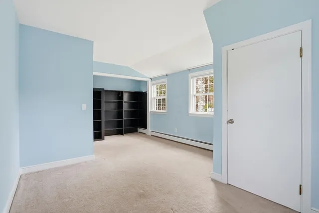 a view of an empty room with closet and windows
