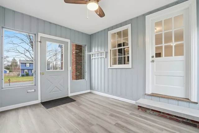 an empty room with wooden floor cabinet and windows