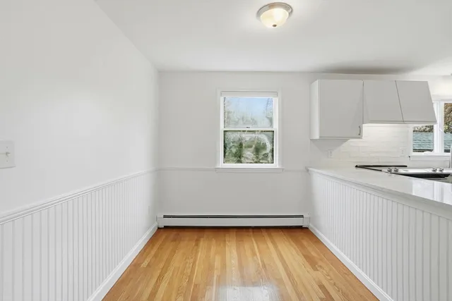 a view of a kitchen with wooden floor and electronic appliances