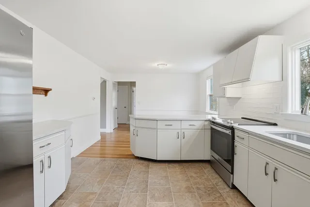 a kitchen with granite countertop white cabinets and white appliances