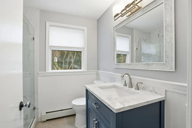 a bathroom with a toilet sink and mirror