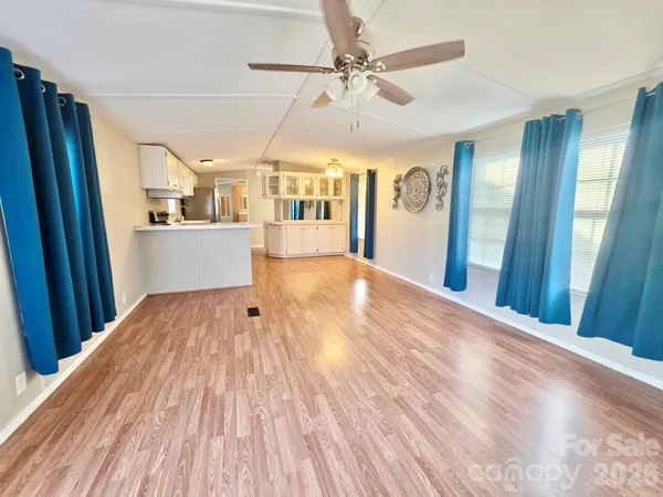 a view of a big room with wooden floor and windows