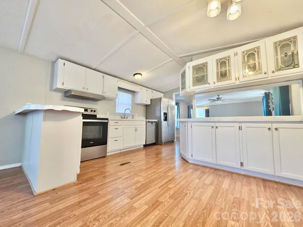 a kitchen with cabinets and wooden floor