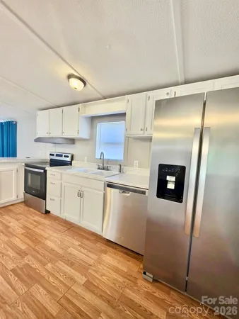 a kitchen with granite countertop a refrigerator and a stove top oven