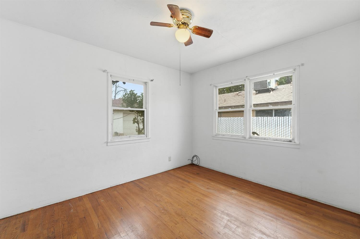 1127 West 19th Street Merced, CA 95340 - Photo 16 of 28 an empty room with windows and chandelier fan
