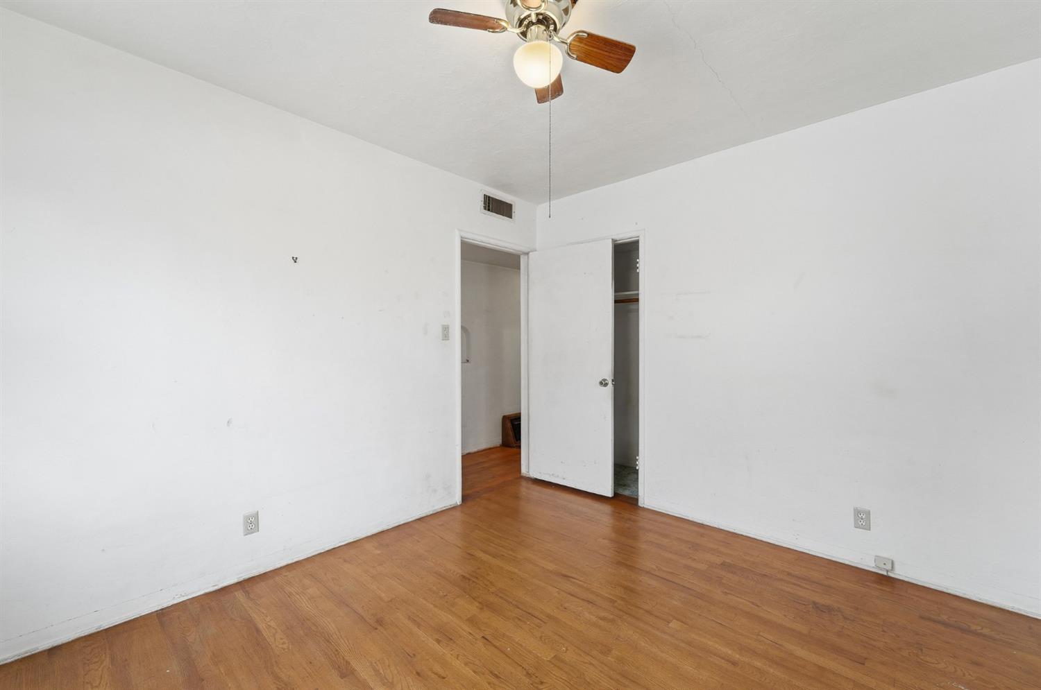 1127 West 19th Street Merced, CA 95340 - Photo 17 of 28 a view of a room with wooden floor and a ceiling fan