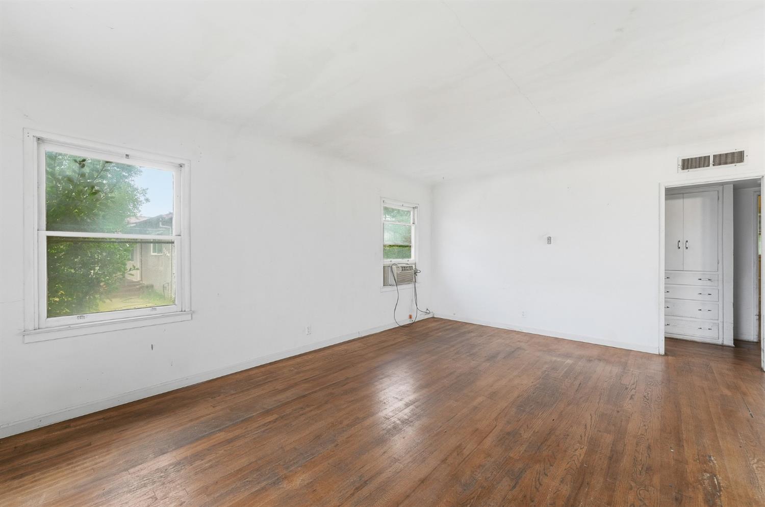 1127 West 19th Street Merced, CA 95340 - Photo 5 of 28 an empty room with wooden floor and windows