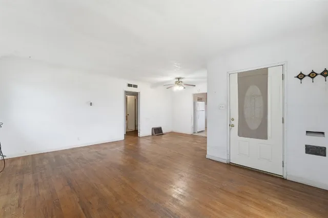 an empty room with wooden floor and mirror