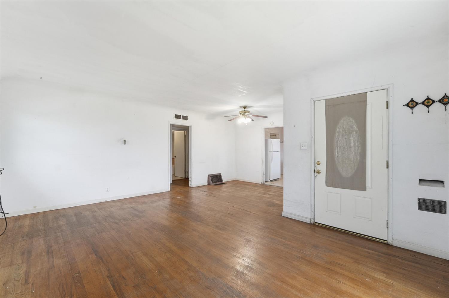 1127 West 19th Street Merced, CA 95340 - Photo 6 of 28 an empty room with wooden floor and mirror