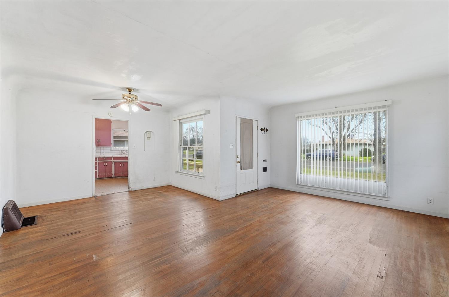 1127 West 19th Street Merced, CA 95340 - Photo 7 of 28 wooden floor in an empty room with a window