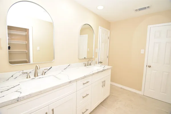a bathroom with a double vanity sink and a mirror