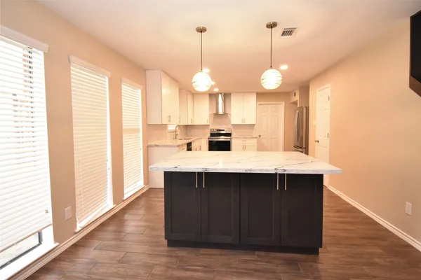 a kitchen with a sink cabinets and wooden floor