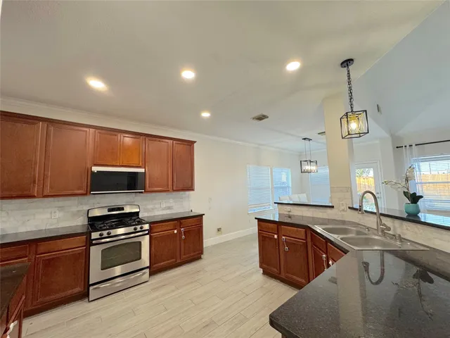 a kitchen with stainless steel appliances granite countertop a sink and cabinets
