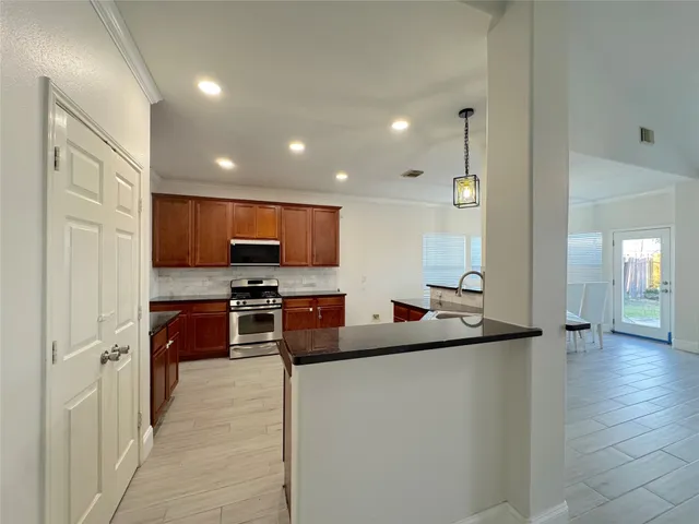 a large kitchen with stainless steel appliances granite countertop a stove and a sink