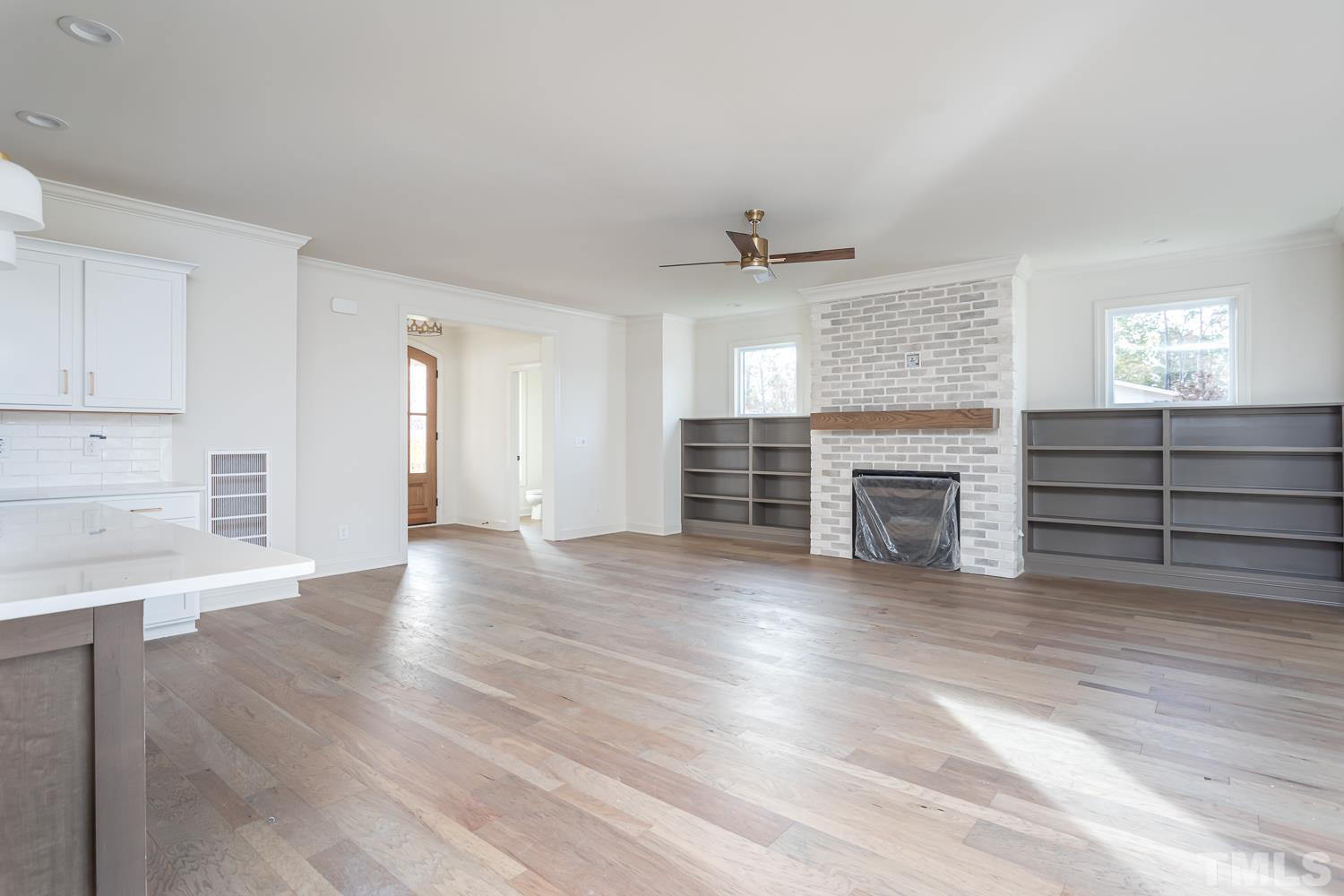 76 Bucchero Lane Clayton, NC 27527 - Photo 11 of 41 an empty room with wooden floor fireplace and windows