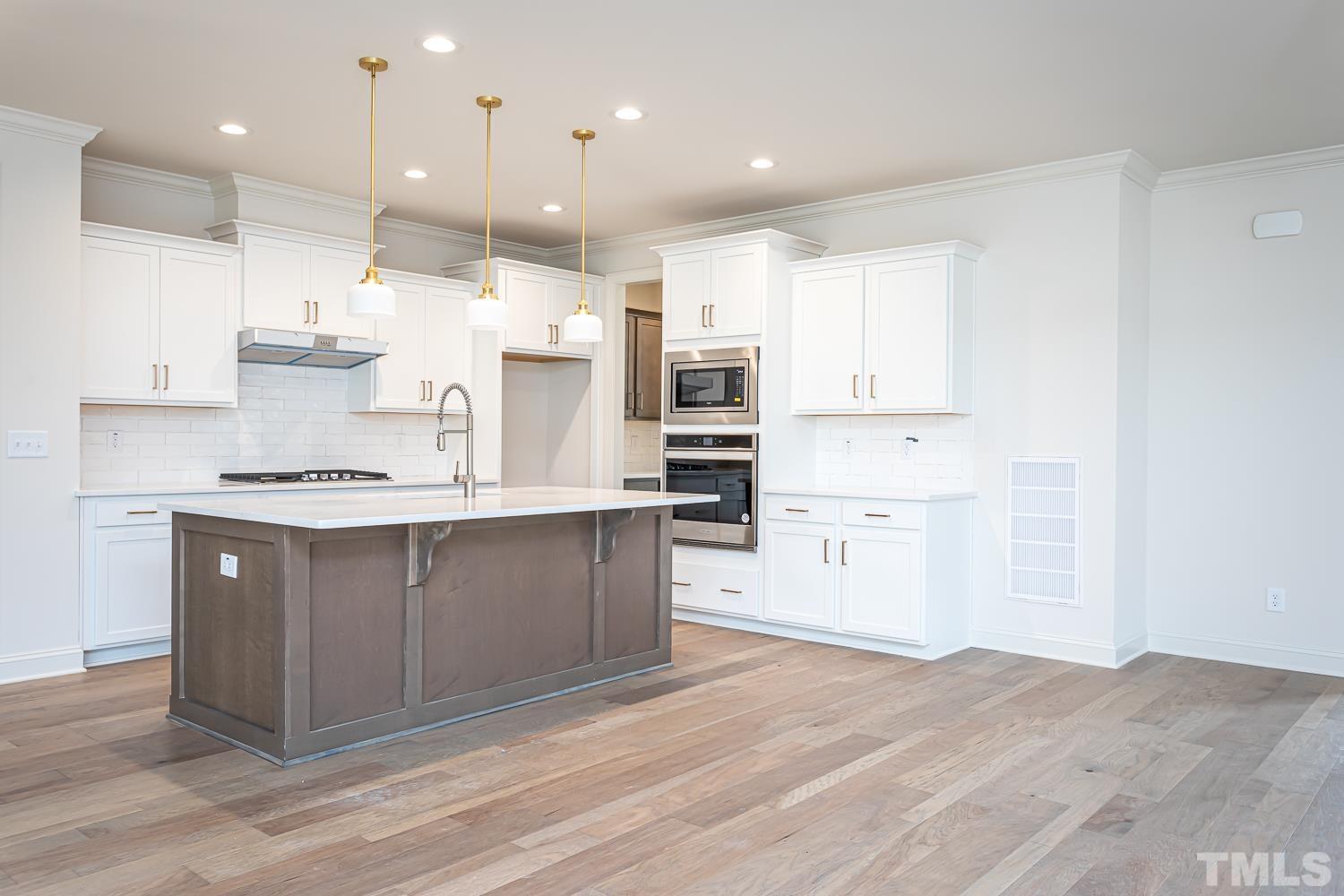 76 Bucchero Lane Clayton, NC 27527 - Photo 7 of 41 a kitchen with kitchen island a sink stainless steel appliances and cabinets