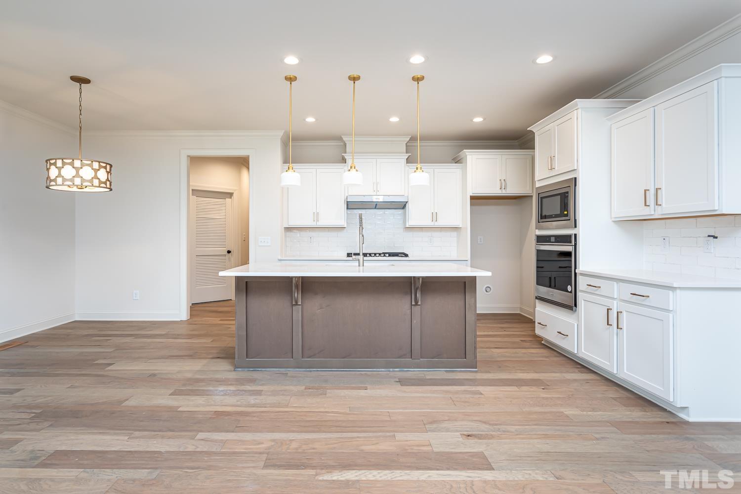 76 Bucchero Lane Clayton, NC 27527 - Photo 8 of 41 a large kitchen with granite countertop a large counter top a sink stainless steel appliances and cabinets