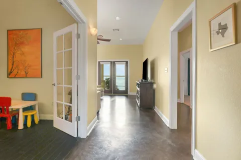 a view of a hallway with wooden floor and windows