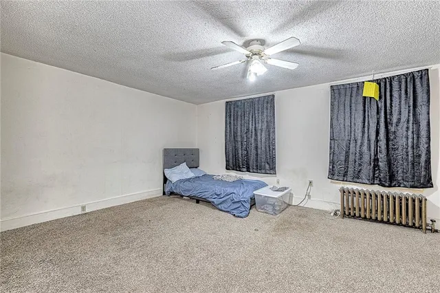 a spacious bedroom with a bed and a chandelier