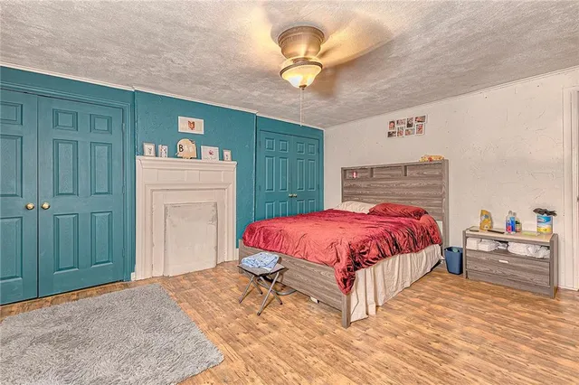 a bedroom with a bed and a flat tv screen on wall