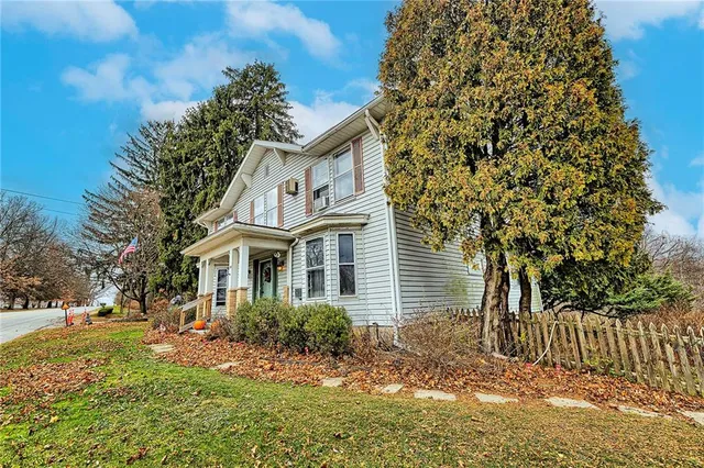 a view of a house with a small yard and wooden fence