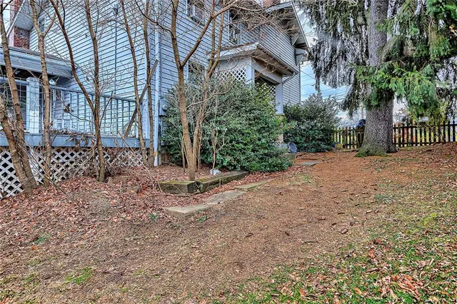 a view of a house with backyard and trees